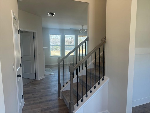 stairway featuring visible vents, wood finished floors, a ceiling fan, and baseboards