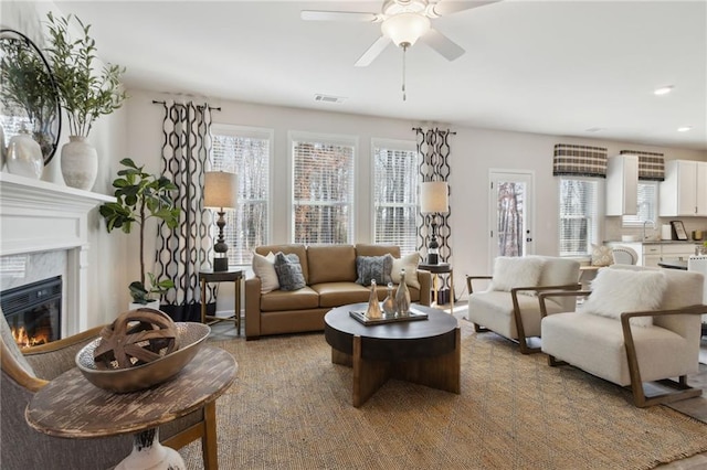 living room with ceiling fan, a premium fireplace, visible vents, and recessed lighting