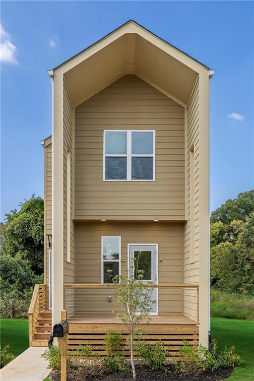 rear view of property featuring a lawn