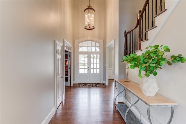 1485 Rolling Links Dr, Alpharetta, GA 30004 - entryway featuring a towering ceiling, a chandelier, dark wood-style flooring, stairs, and baseboards