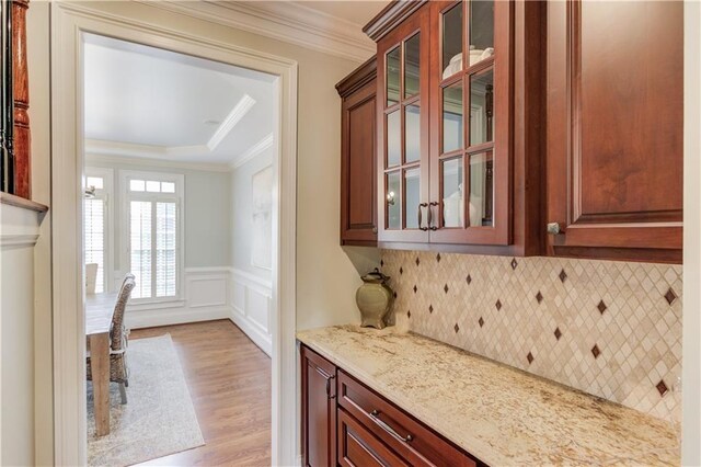 1485 Rolling Links Dr, Alpharetta, GA 30004 - kitchen with light wood-style flooring, crown molding, light stone counters, glass insert cabinets, and a raised ceiling