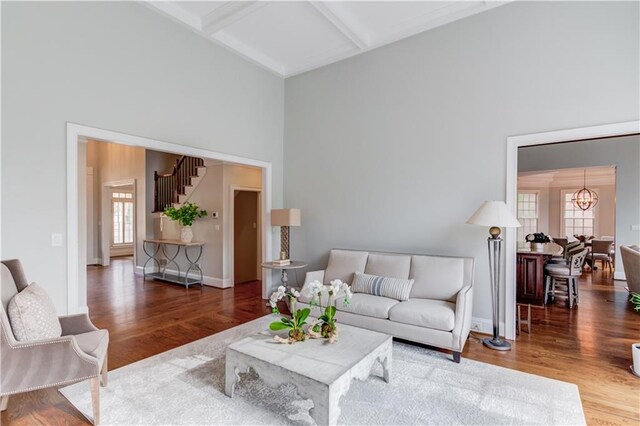 1485 Rolling Links Dr, Alpharetta, GA 30004 - living room featuring a high ceiling, wood finished floors, beam ceiling, a chandelier, and baseboards