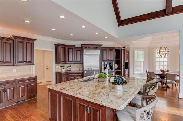 1485 Rolling Links Dr, Alpharetta, GA 30004 - kitchen with ornamental molding, a sink, recessed lighting, a chandelier, and light stone countertops
