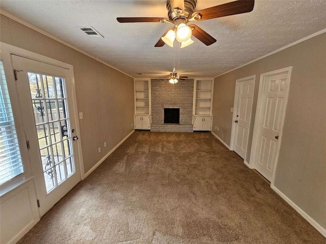 unfurnished living room with dark carpet, built in features, a textured ceiling, and a brick fireplace