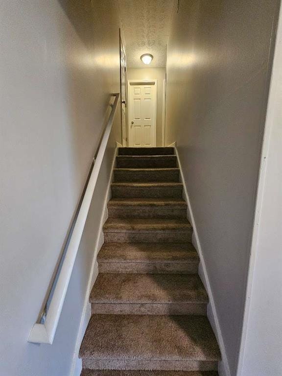 staircase with a textured ceiling