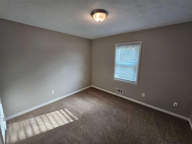 carpeted spare room featuring a textured ceiling