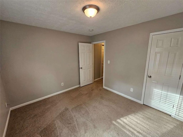 unfurnished bedroom with carpet floors and a textured ceiling