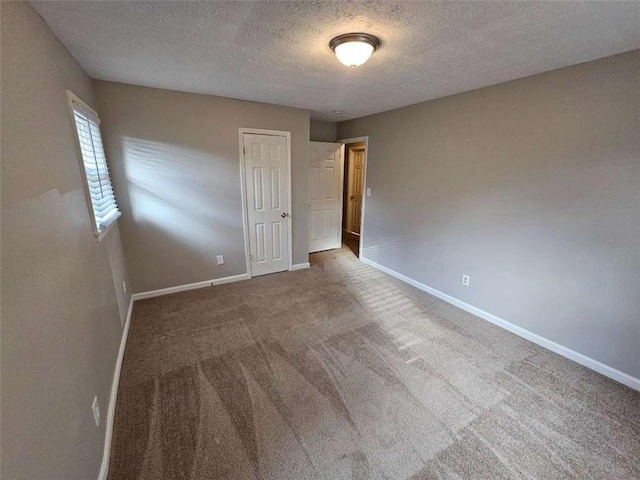 carpeted empty room with a textured ceiling