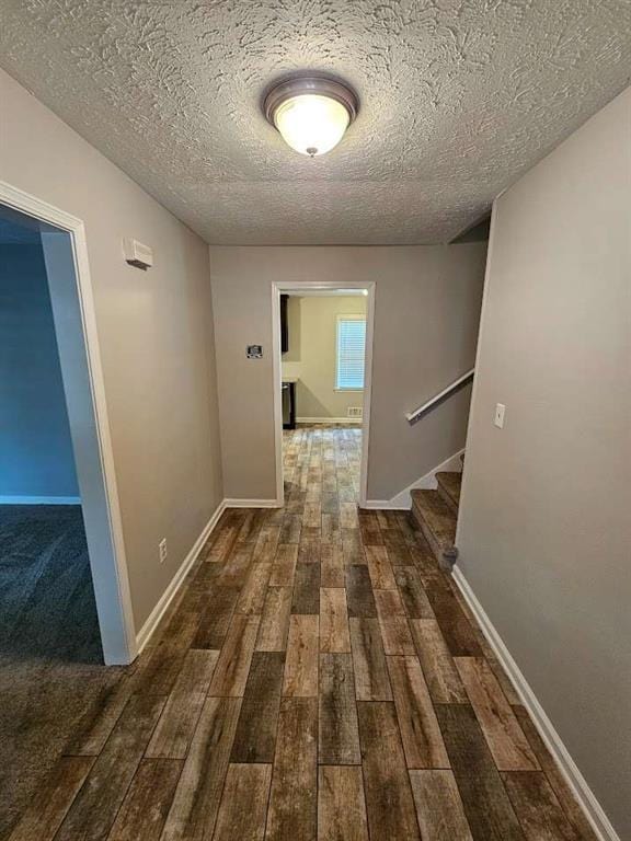hall featuring dark hardwood / wood-style flooring and a textured ceiling