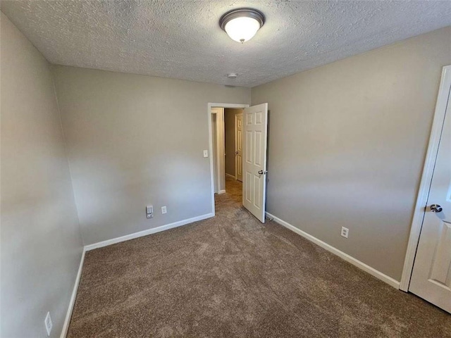 spare room featuring carpet and a textured ceiling