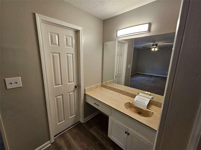 bathroom featuring ceiling fan, hardwood / wood-style floors, vanity, and a textured ceiling