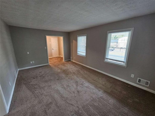 interior space featuring carpet flooring and a textured ceiling