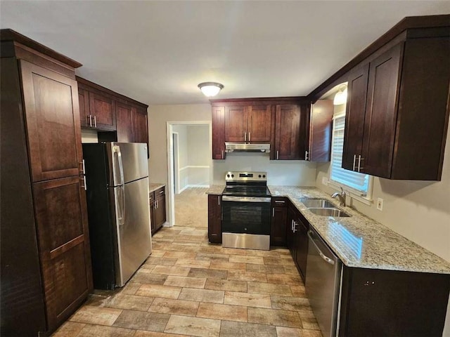 kitchen with light stone countertops, sink, and stainless steel appliances