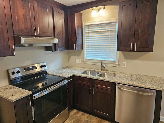 kitchen featuring light stone counters, sink, stainless steel appliances, and light wood-type flooring