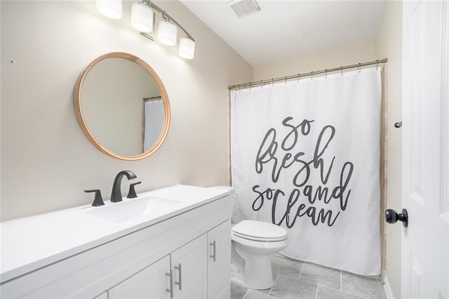 bathroom with vanity, curtained shower, and toilet