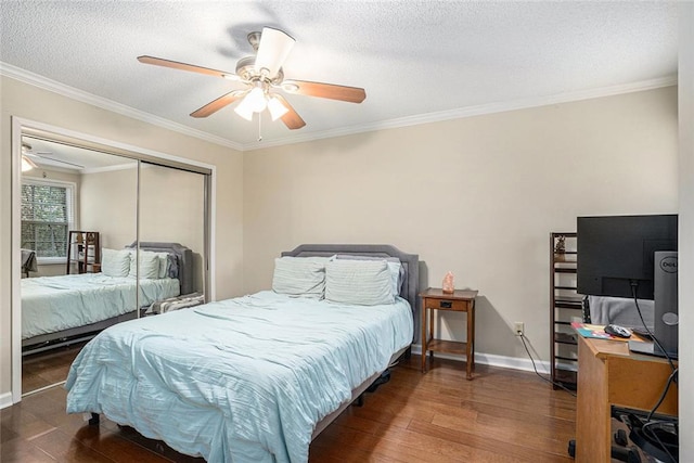 bedroom with ceiling fan, crown molding, dark wood-type flooring, a textured ceiling, and a closet