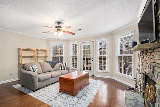 living room featuring ornamental molding, hardwood / wood-style floors, ceiling fan, and a fireplace