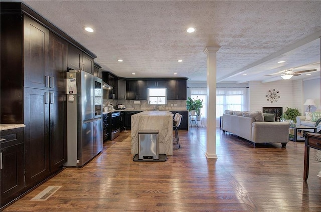 kitchen featuring visible vents, open floor plan, light countertops, ornate columns, and smart refrigerator