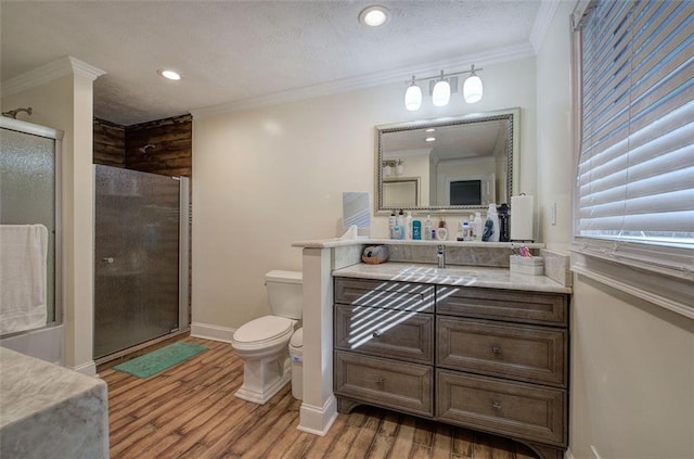 full bath with toilet, wood finished floors, vanity, ornamental molding, and a shower stall