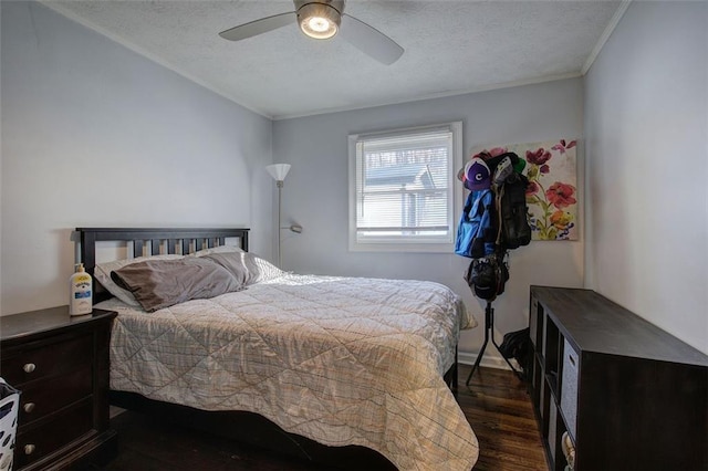 bedroom with a ceiling fan, a textured ceiling, ornamental molding, and dark wood-type flooring