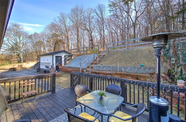 wooden deck featuring an outbuilding and outdoor dining area