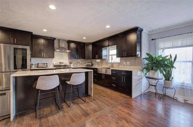 kitchen with dark wood finished floors, stainless steel electric range oven, backsplash, a kitchen island, and wall chimney exhaust hood