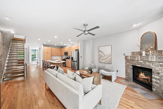 1344 Fernwood Cir NE, Brookhaven, GA 30319 - living room with a brick fireplace, stairway, light wood finished floors, ceiling fan, and recessed lighting