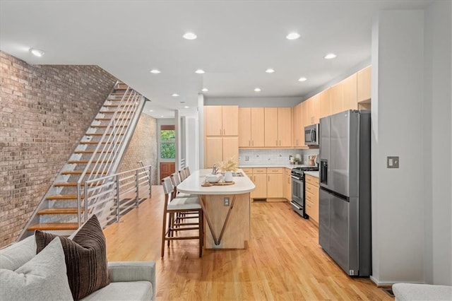 1344 Fernwood Cir NE, Brookhaven, GA 30319 - kitchen with stainless steel appliances, light brown cabinetry, brick wall, light wood-style floors, and light countertops