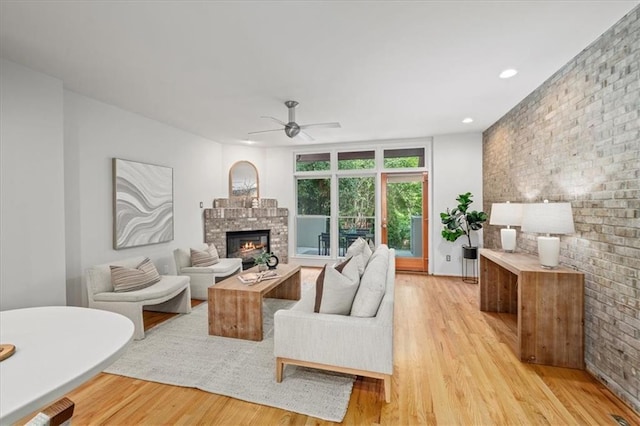 1344 Fernwood Cir NE, Brookhaven, GA 30319 - living area featuring a glass covered fireplace, light wood-type flooring, ceiling fan, recessed lighting, and brick wall