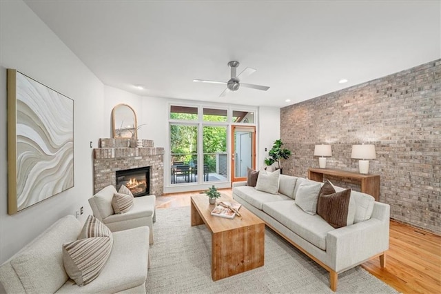 1344 Fernwood Cir NE, Brookhaven, GA 30319 - living area featuring wood finished floors, a ceiling fan, a glass covered fireplace, brick wall, and recessed lighting