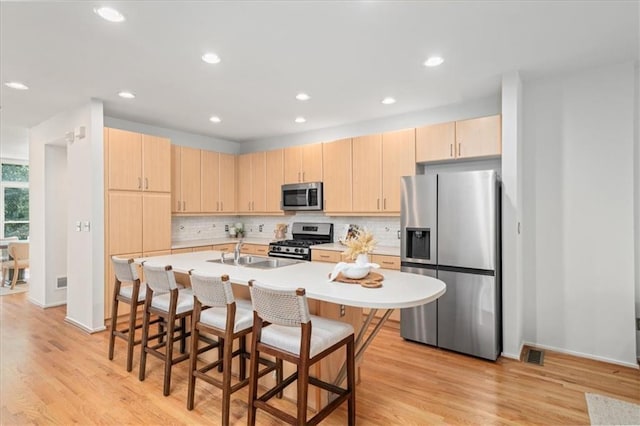 1344 Fernwood Cir NE, Brookhaven, GA 30319 - kitchen with stainless steel appliances, light brown cabinets, tasteful backsplash, a breakfast bar area, and light countertops