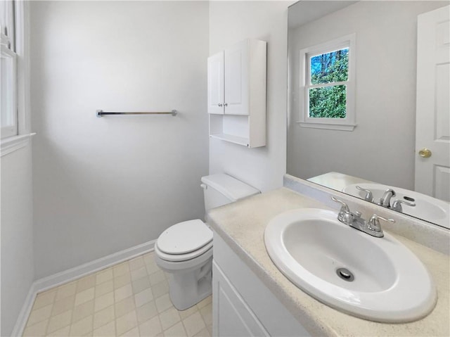 half bath featuring toilet, baseboards, and vanity