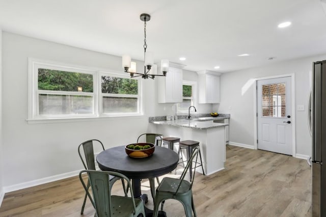 2519 Miriam Ln, Decatur, GA 30032 - dining room featuring baseboards, recessed lighting, an inviting chandelier, and light wood-style floors