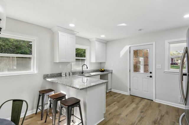 2519 Miriam Ln, Decatur, GA 30032 - kitchen with white cabinetry, light stone countertops, a sink, and a healthy amount of sunlight