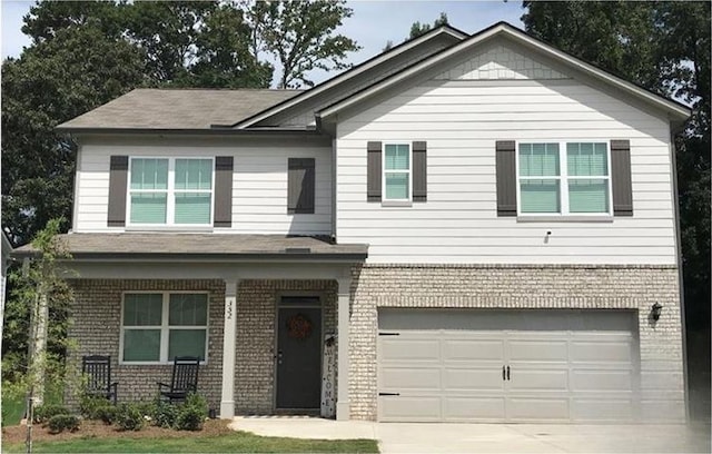 view of front facade with driveway, a garage, and brick siding