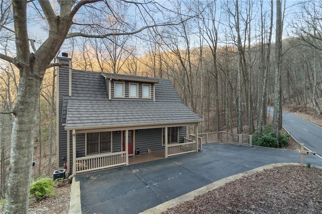 view of front of house with covered porch and a chimney