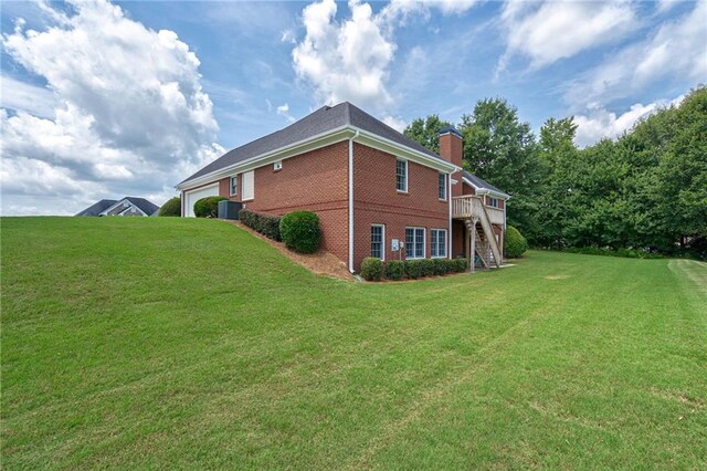 view of side of property with a wooden deck and a yard