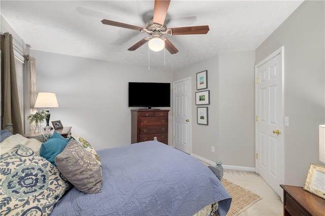 carpeted bedroom with a textured ceiling, ceiling fan, and baseboards