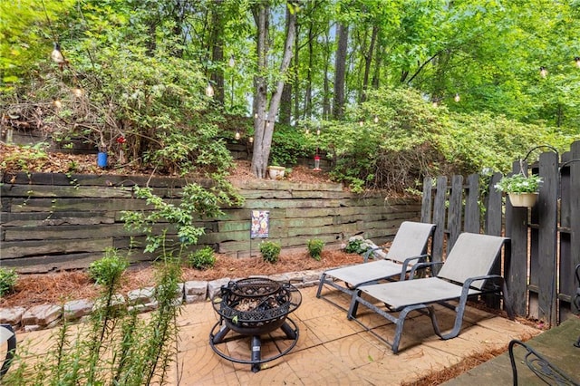 view of patio / terrace with an outdoor fire pit and fence