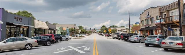 view of asphalt road featuring street lighting and traffic lights