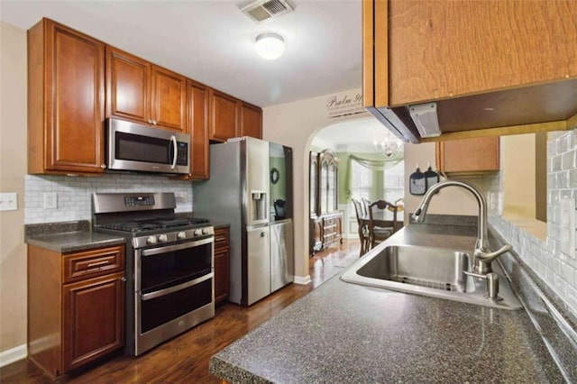 1127 Oak Hollow Ct, Hampton, GA 30228 - kitchen featuring stainless steel appliances, a sink, dark countertops, backsplash, and dark wood-type flooring