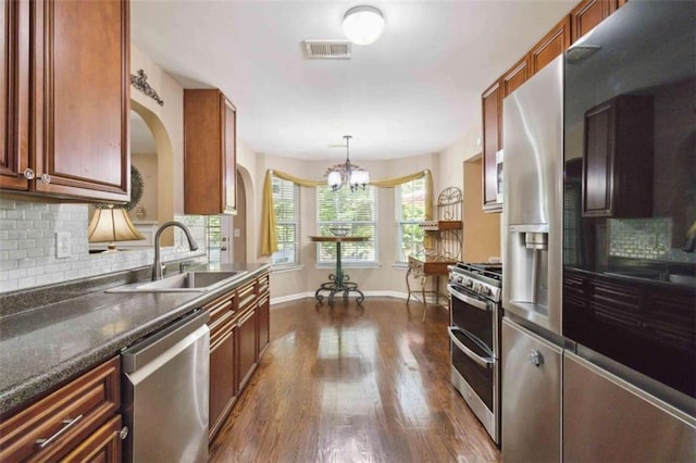1127 Oak Hollow Ct, Hampton, GA 30228 - kitchen with stainless steel appliances, a sink, a chandelier, dark wood finished floors, and tasteful backsplash
