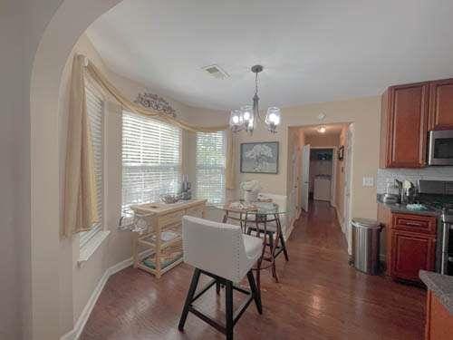1127 Oak Hollow Ct, Hampton, GA 30228 - dining area featuring arched walkways, a chandelier, baseboards, and wood finished floors