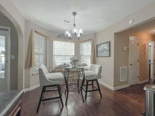 1127 Oak Hollow Ct, Hampton, GA 30228 - dining space featuring baseboards, wood finished floors, plenty of natural light, and a chandelier