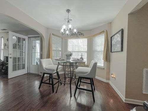 1127 Oak Hollow Ct, Hampton, GA 30228 - dining area featuring a chandelier, wood finished floors, baseboards, and arched walkways