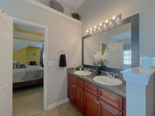 1127 Oak Hollow Ct, Hampton, GA 30228 - ensuite bathroom featuring double vanity, vaulted ceiling, and tile patterned floors