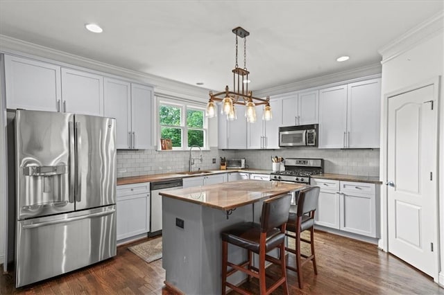 1622 Gates Pl NW, Atlanta, GA 30318 - kitchen featuring stainless steel appliances, a breakfast bar, hanging light fixtures, a kitchen island, and decorative backsplash