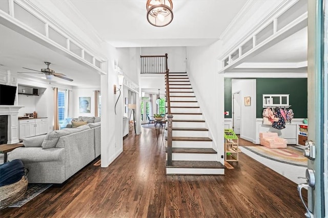 1622 Gates Pl NW, Atlanta, GA 30318 - entrance foyer featuring a fireplace, stairs, wood finished floors, ceiling fan, and crown molding