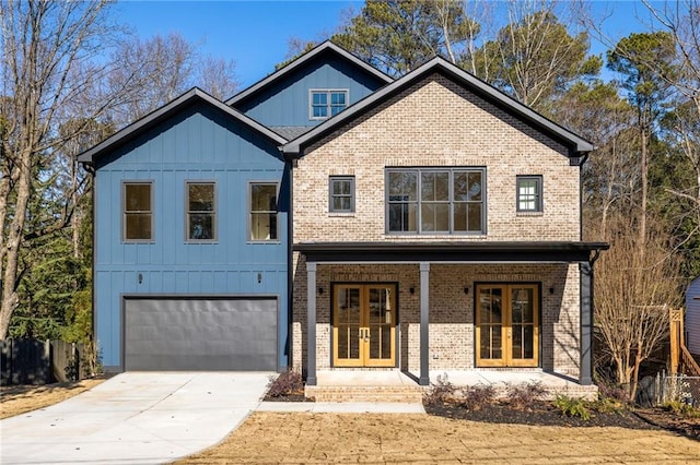 view of front of property featuring covered porch, a garage, and french doors