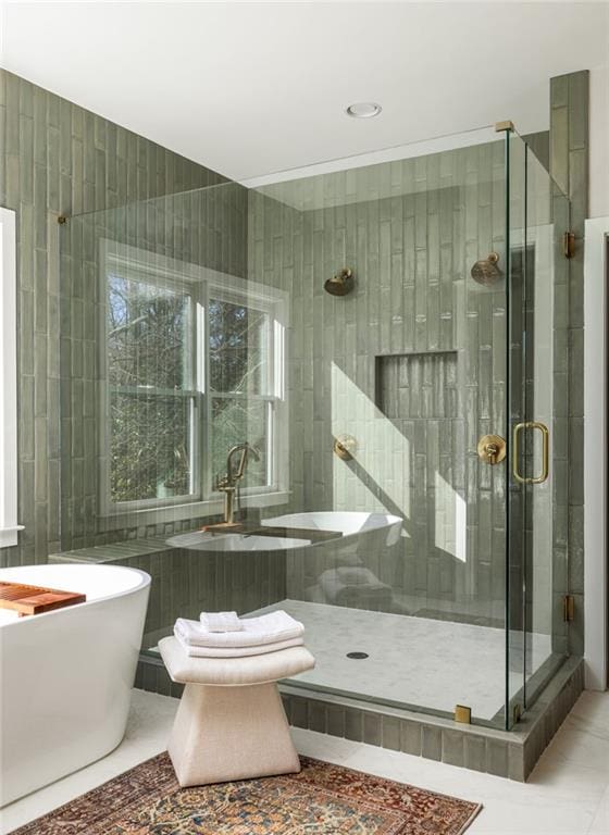 bathroom featuring tile walls, tile patterned floors, and separate shower and tub